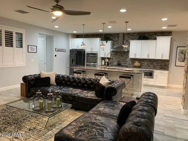 a living room with stainless steel appliances furniture stove and kitchen view