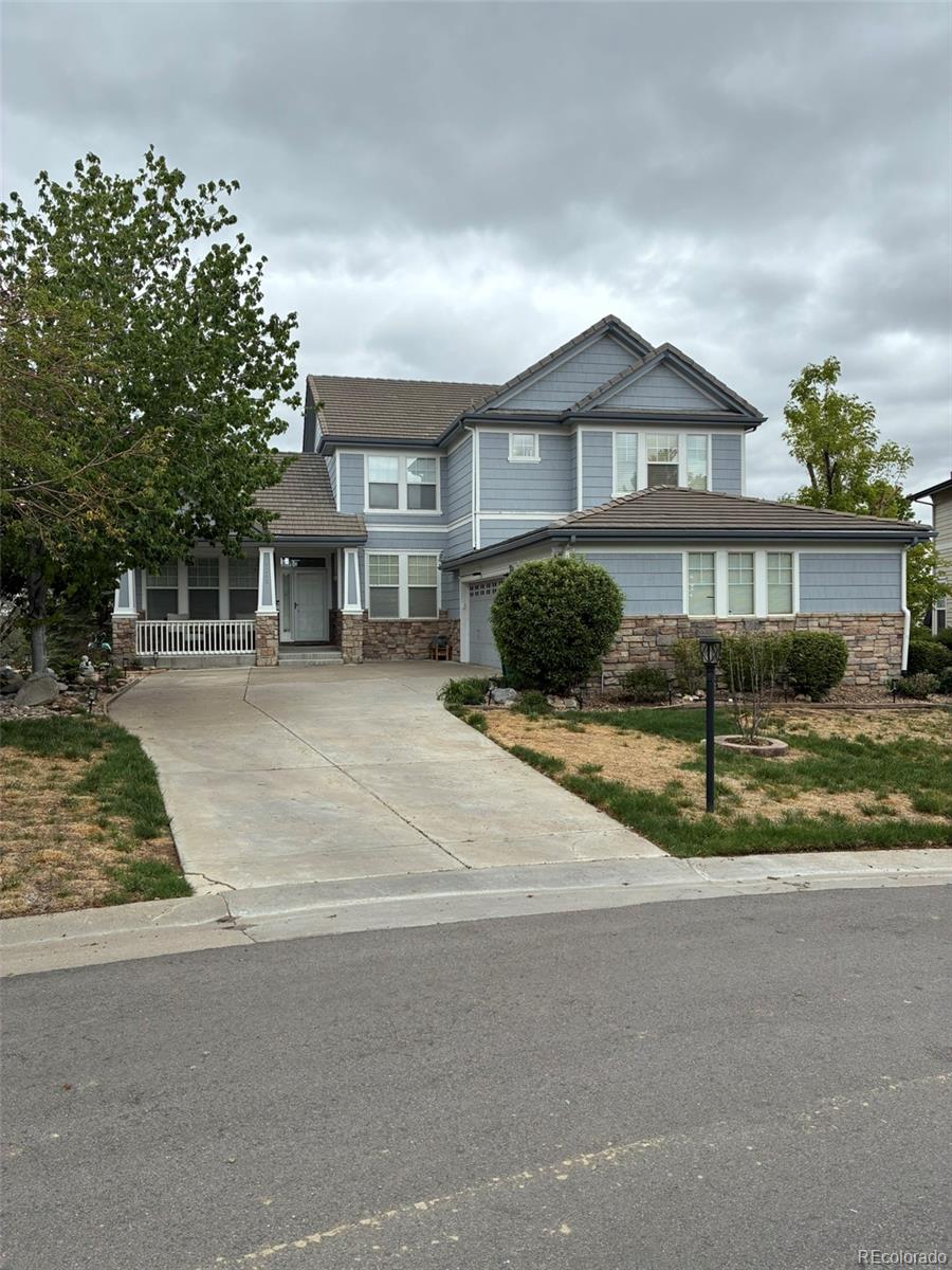 7242 South Rome Street Aurora, CO 80016 - Photo 2 of 33 a front view of a house with a yard and potted plants