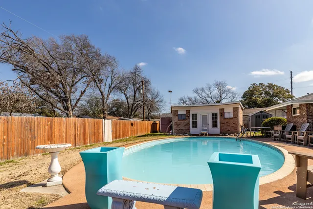 a view of a house with pool and chairs