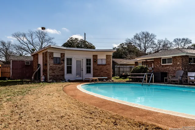 a view of a house with swimming pool and sitting area