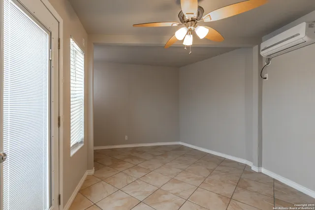 en empty room with window and chandelier fan
