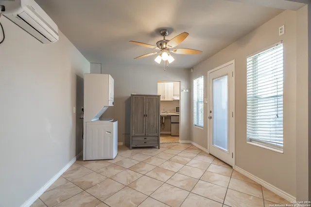 a view of a livingroom with a chandelier fan and windows