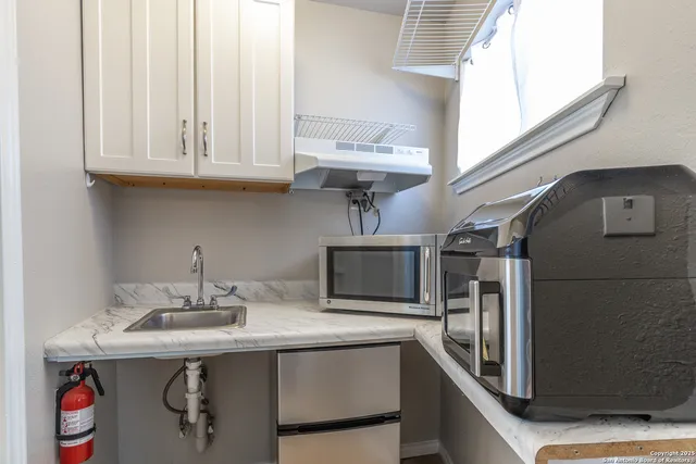 a kitchen with stainless steel appliances granite countertop a sink and a microwave