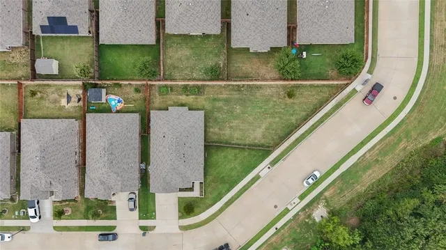 an aerial view of residential houses with outdoor space and street view