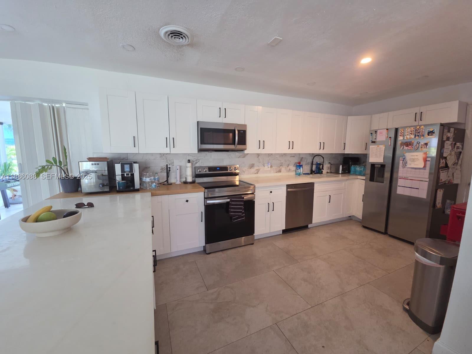 14001 Mustang Trail, Unit 1 Southwest Ranches, FL 33330 - Photo 22 of 31 a kitchen with stainless steel appliances granite countertop a refrigerator sink and stove
