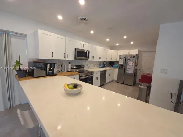 a living room with furniture and a kitchen view