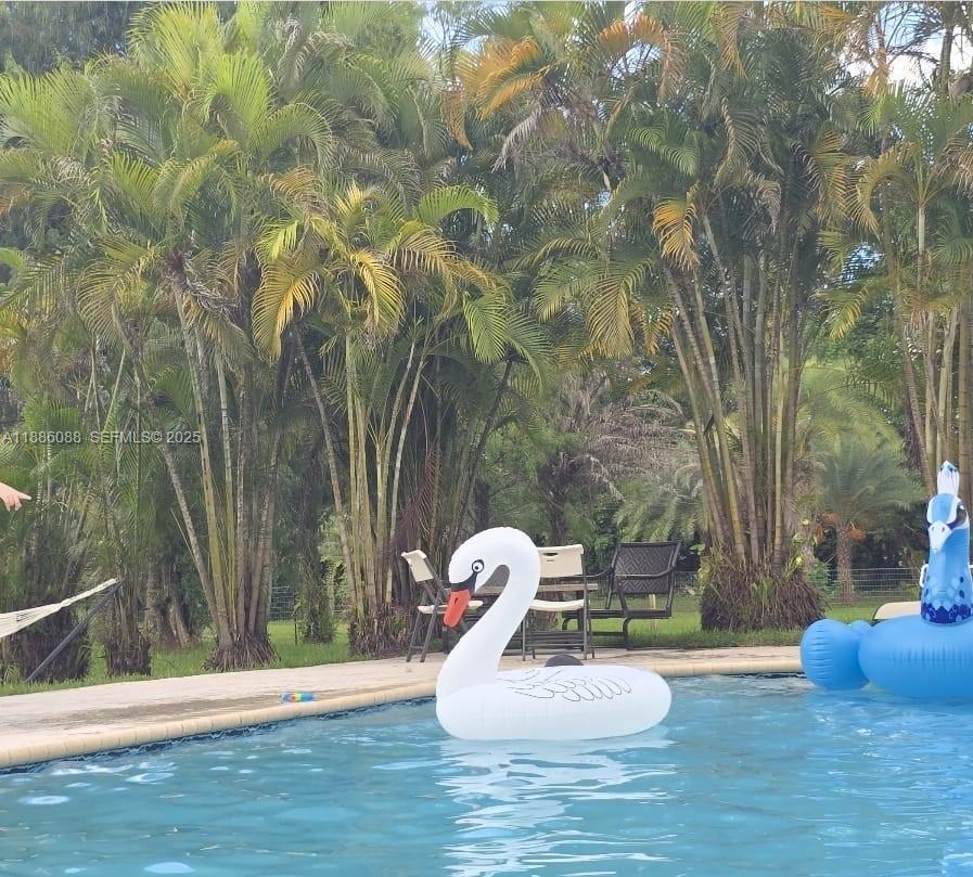 14001 Mustang Trail, Unit 1 Southwest Ranches, FL 33330 - Photo 31 of 31 a backyard of a house with table and chairs