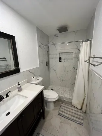 a bathroom with a granite countertop shower and a sink
