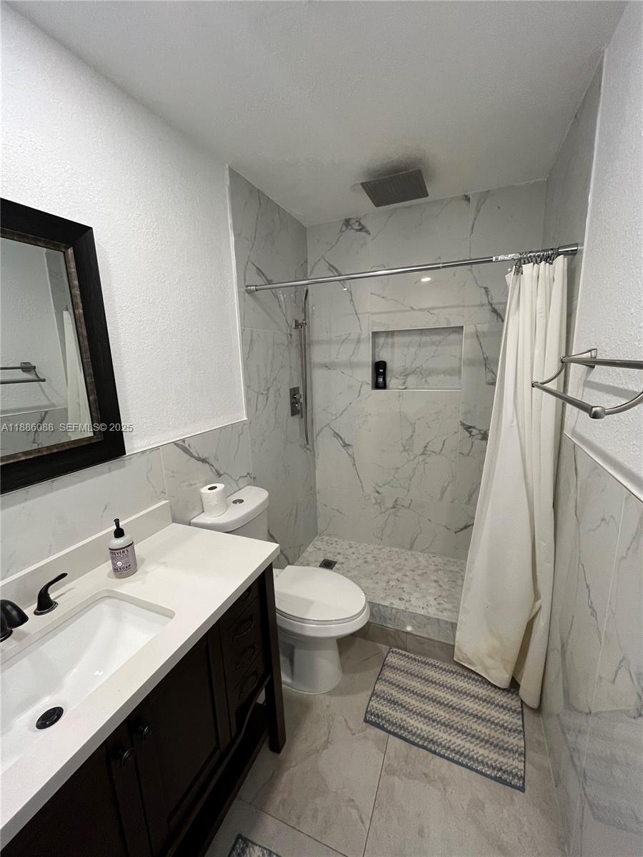 14001 Mustang Trail, Unit 1 Southwest Ranches, FL 33330 - Photo 6 of 31 a bathroom with a sink a toilet and shower