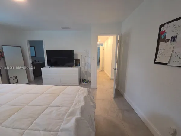 a bedroom with a large bed and a flat screen tv