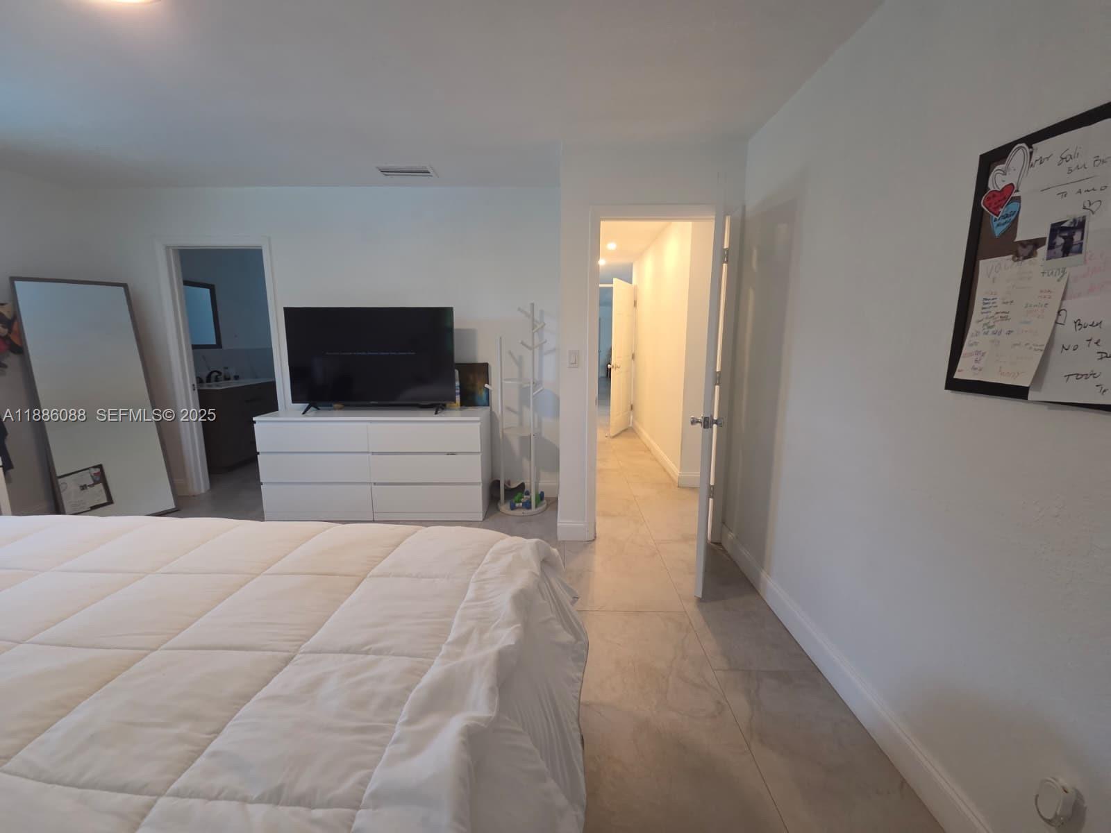 14001 Mustang Trail, Unit 1 Southwest Ranches, FL 33330 - Photo 10 of 31 a bedroom with a bed and a flat screen tv