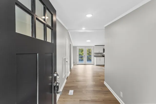 a view of a hallway with wooden floor and staircase