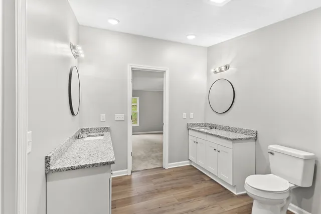 a bathroom with a granite countertop sink a toilet and shower