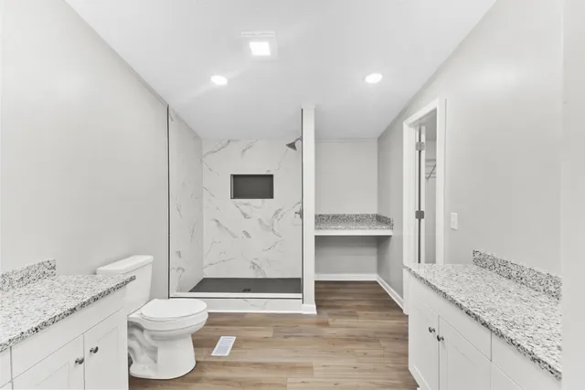 a kitchen with granite countertop a stove a sink and a wooden floor