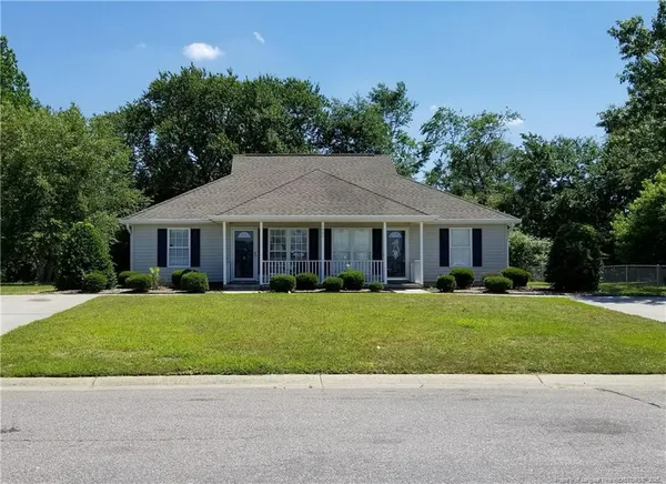 a front view of a house with a garden and yard