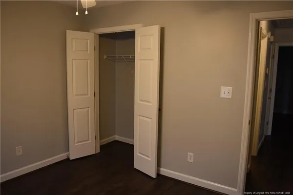 an empty room with wooden floor and closet