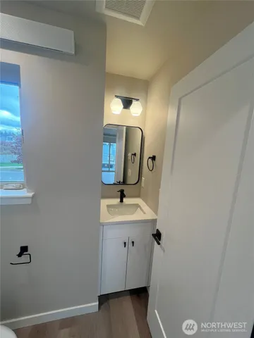 a bathroom with a sink and mirror with toilet