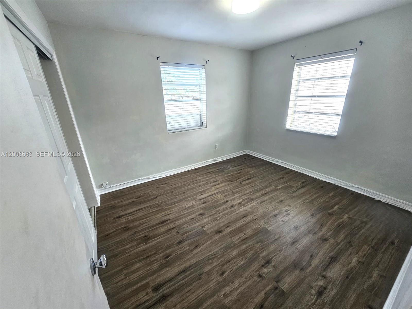10790 Southwest 46th Street, Unit 10790 Miami, FL 33165 - Photo 11 of 19 a view of an empty room with wooden floor and a window