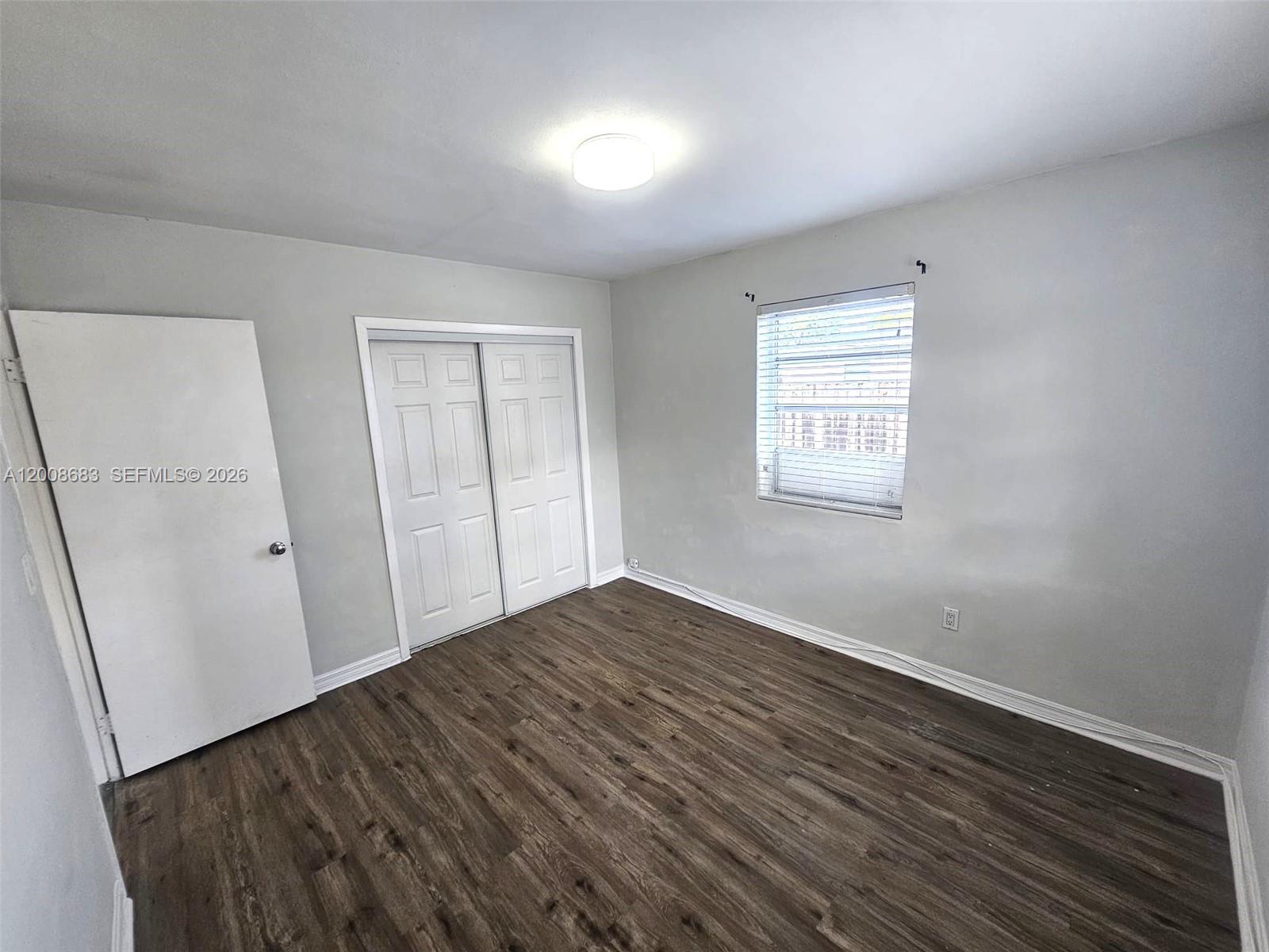 10790 Southwest 46th Street, Unit 10790 Miami, FL 33165 - Photo 4 of 19 an empty room with wooden floor and windows