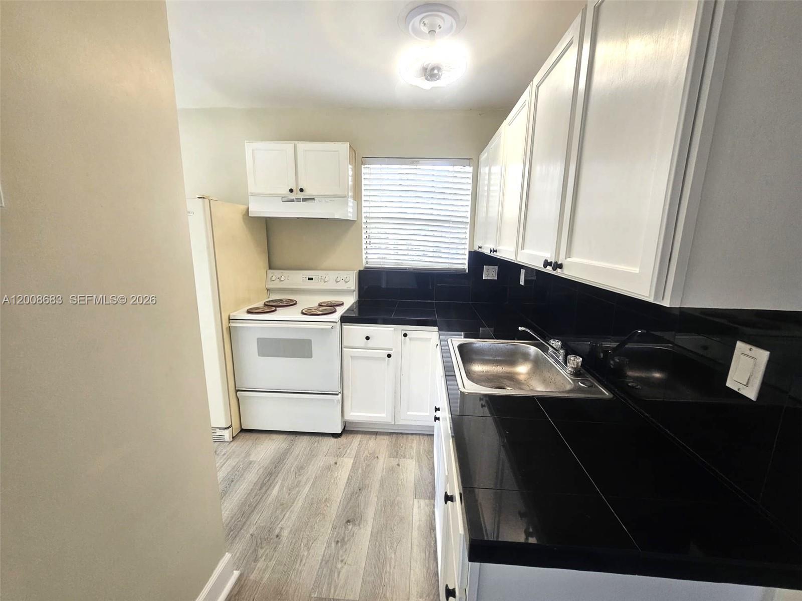 10790 Southwest 46th Street, Unit 10790 Miami, FL 33165 - Photo 8 of 19 a kitchen with a sink a stove and refrigerator