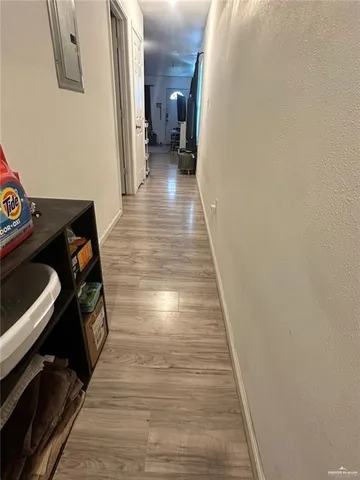 a view of a hallway with wooden floor and staircase