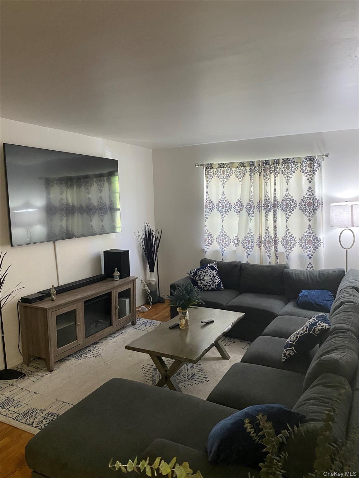 84-24 98th Street, Unit 1 Queens, NY 11421 - Photo 7 of 22 a living room with furniture and a flat screen tv