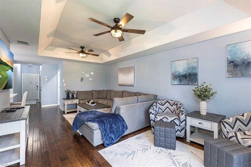 809 Augusta Boulevard, Unit 3 Naples, FL 34113 - Photo 11 of 32 Living room with a raised ceiling, ceiling fans, and dark wood finished floors