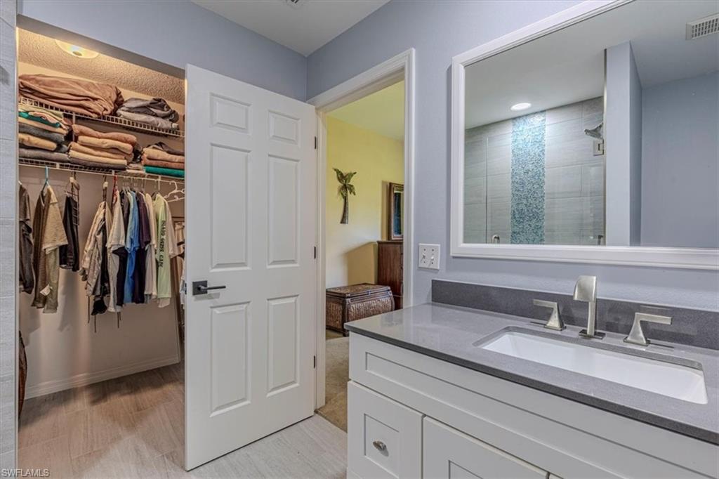 809 Augusta Boulevard, Unit 3 Naples, FL 34113 - Photo 24 of 32 Bathroom with a shower stall, vanity, a spacious closet, and recessed lighting