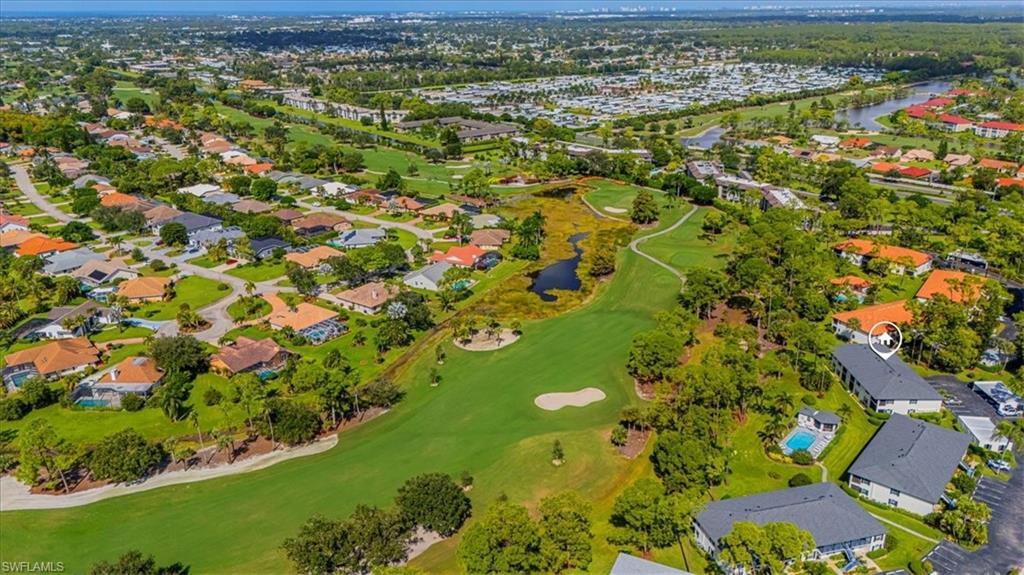 809 Augusta Boulevard, Unit 3 Naples, FL 34113 - Photo 6 of 32 Aerial view of residential area with a nearby body of water and a golf course