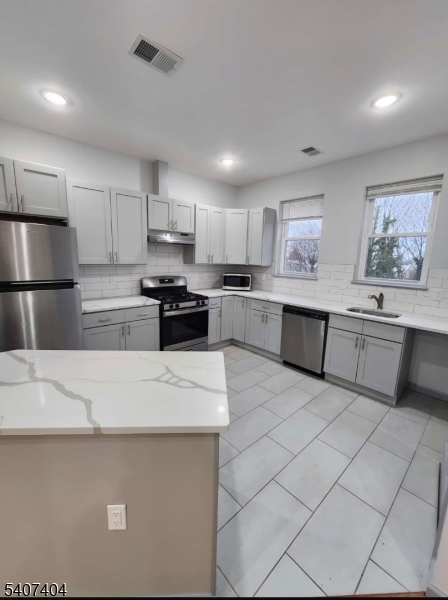 296 Chadwick Avenue Newark, NJ 07112 - Photo 2 of 12 a kitchen with stainless steel appliances granite countertop a refrigerator sink and cabinets