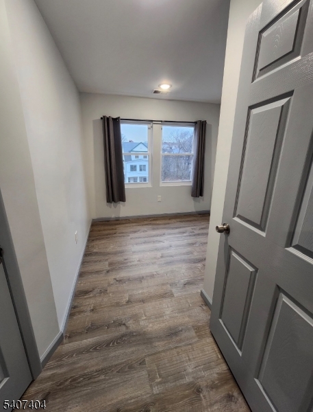 296 Chadwick Avenue Newark, NJ 07112 - Photo 7 of 12 a view of an empty room with wooden floor and stairs