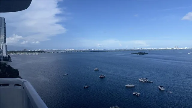 a view of lake with boats and trees in the background