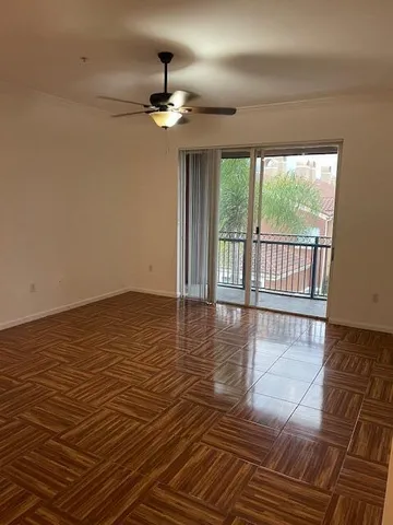 a view of a room with wooden floor fan and window