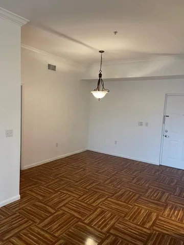 a view of a room with a ceiling fan and hardwood floor