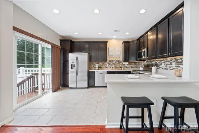 a kitchen with stainless steel appliances kitchen island granite countertop a refrigerator and cabinets