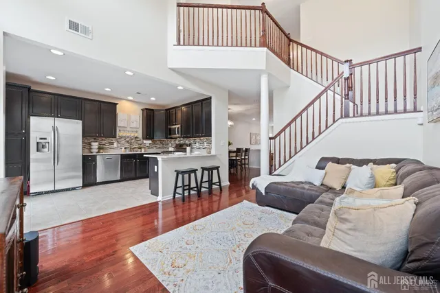 a living room with furniture and kitchen view with wooden floor