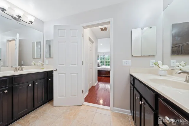 a spacious bathroom with a double vanity sink a mirror and a shower