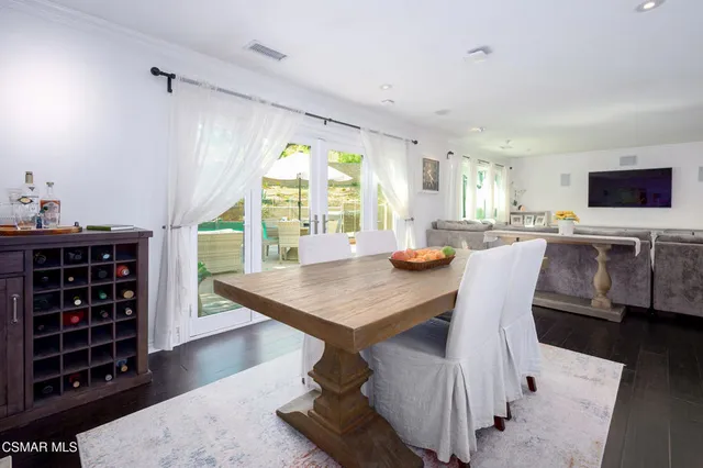 a large white kitchen with granite countertop a stove a sink a window and white cabinets