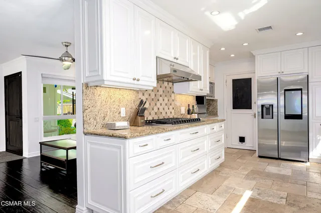 a kitchen with granite countertop white cabinets and white appliances