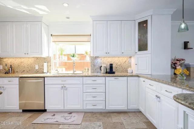 a kitchen with granite countertop cabinets a sink a window and stainless steel appliances