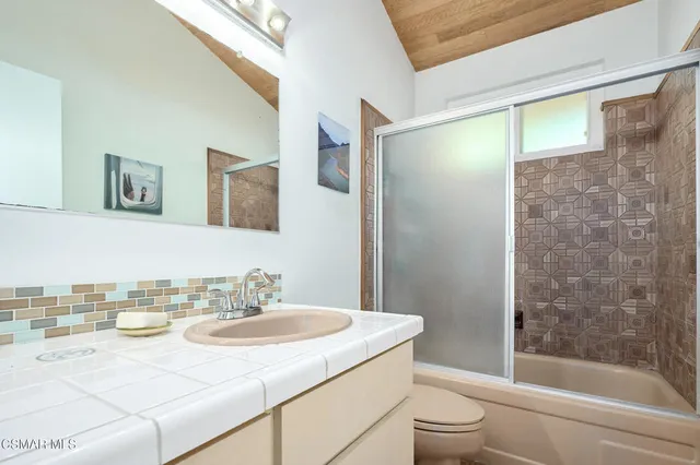 a bedroom with a bed couch and a window