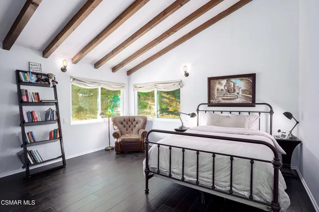 a bedroom with a bed and a flat tv screen on a dresser