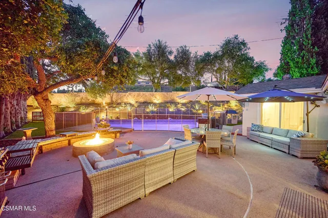 a living room with patio furniture and a large tree