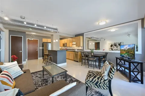 a living room with lots of furniture and view of kitchen