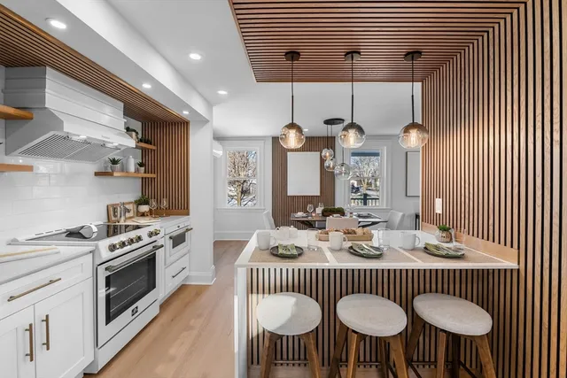 a kitchen with stainless steel appliances kitchen island a table chairs and a sink