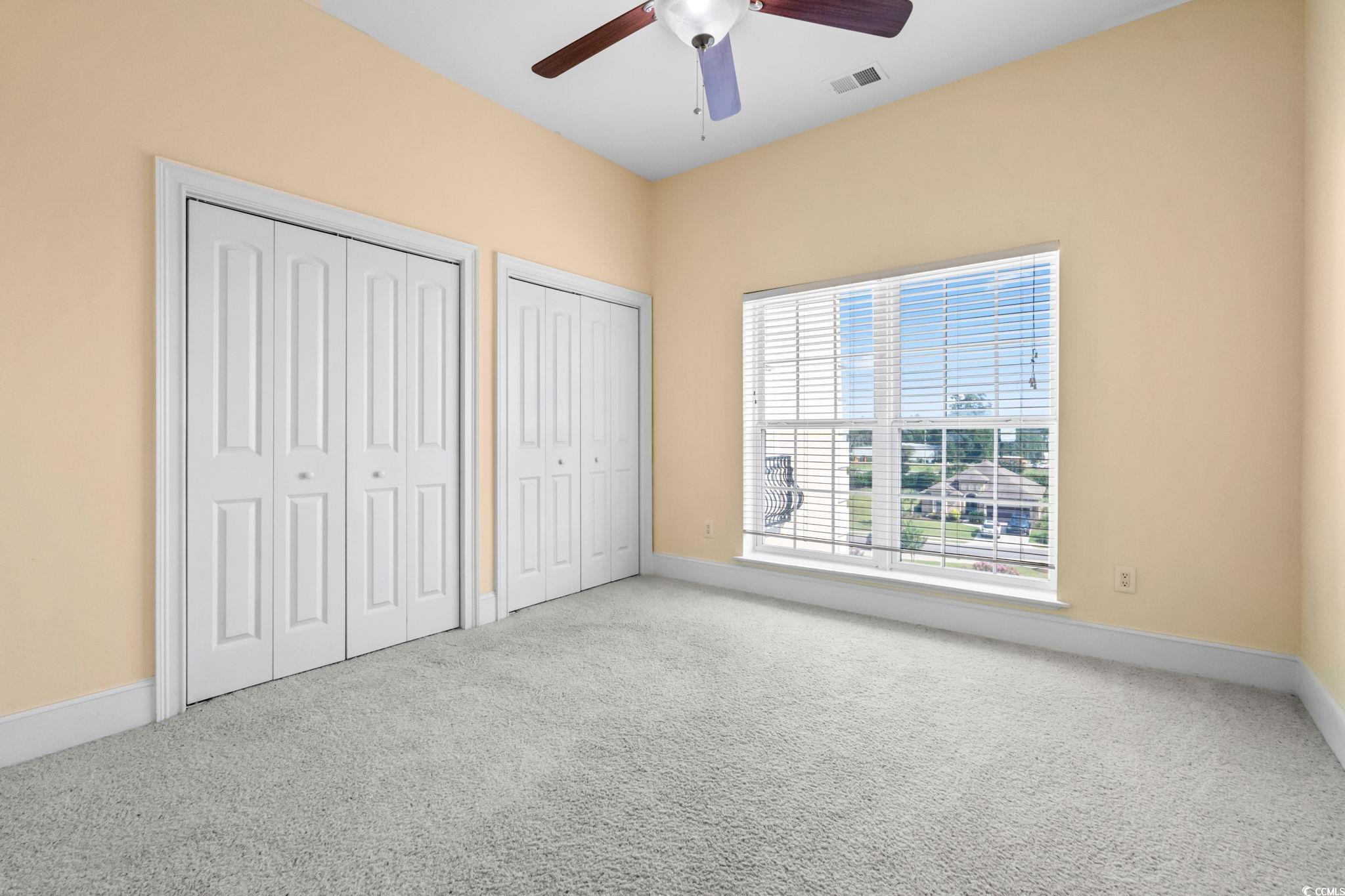 249 Venice Way, Unit 3301 Myrtle Beach, SC 29577 - Photo 29 of 40 Unfurnished bedroom with multiple closets, carpet floors, and a ceiling fan