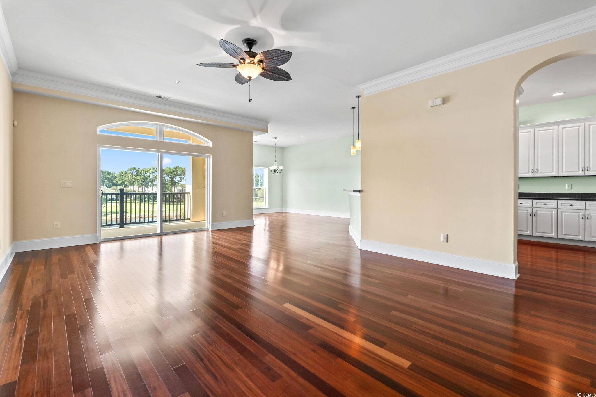 249 Venice Way, Unit 3301 Myrtle Beach, SC 29577 - Photo 5 of 40 Unfurnished room with ornamental molding, dark wood-style floors, a ceiling fan, arched walkways, and a chandelier