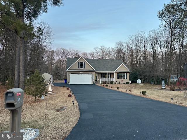 a front view of a house with a yard covered with trees