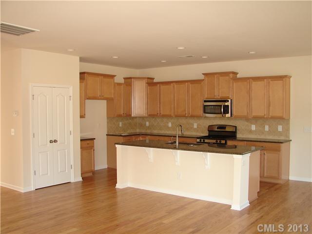 4009 Perth Road, Unit 402 Indian Land, SC 29707 - Photo 6 of 8 a kitchen with stainless steel appliances granite countertop a stove a sink and a refrigerator