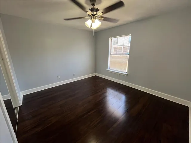 a view of wooden floor and a chandelier fan in a room